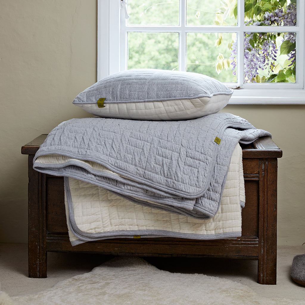 Quilted cushion & kingsize bedspread on ottoman
