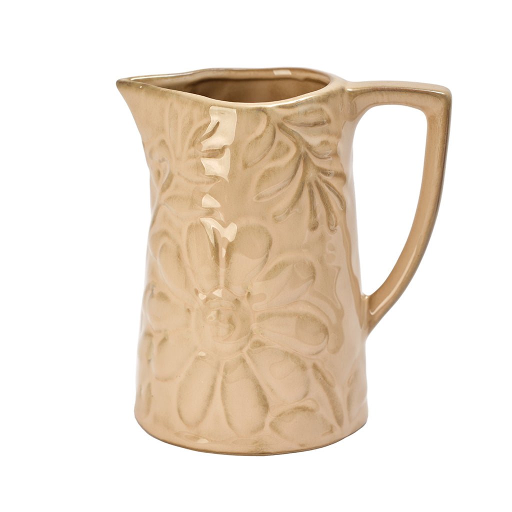 Beige ceramic pitcher with floral embossing on a white background