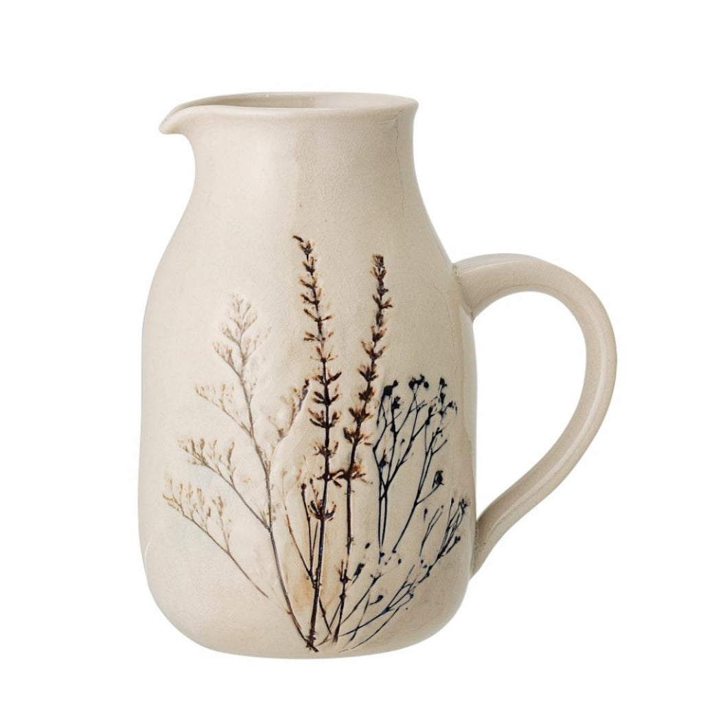 Ceramic pitcher with floral design on a white background