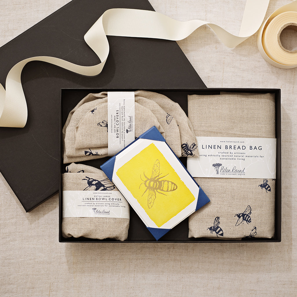 Set of linen products including bread bag, bowl cover, and card with bee design in a box.