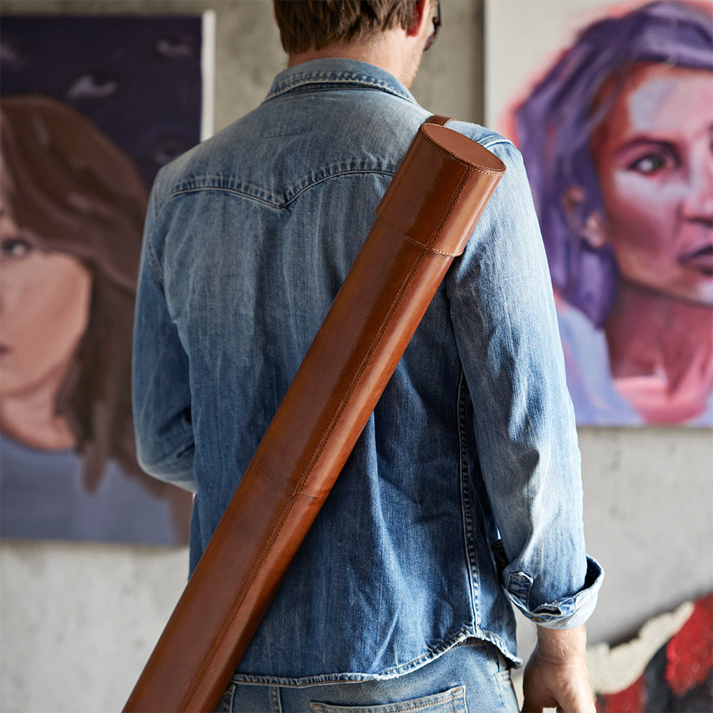 Leather cylinder map documnet case being carried by man with strap over the shoulder