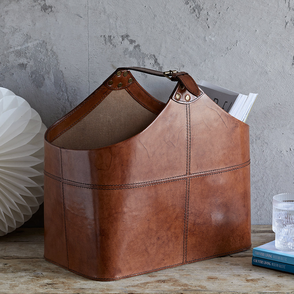 Leather buckled magazine storage basket in conker brown with a few magazines in
