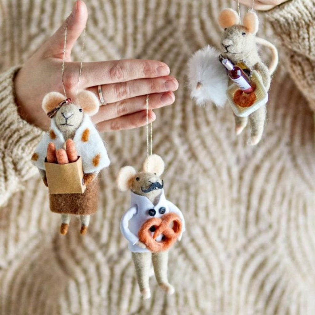 Handmade mouse ornaments with various accessories on a textured fabric background