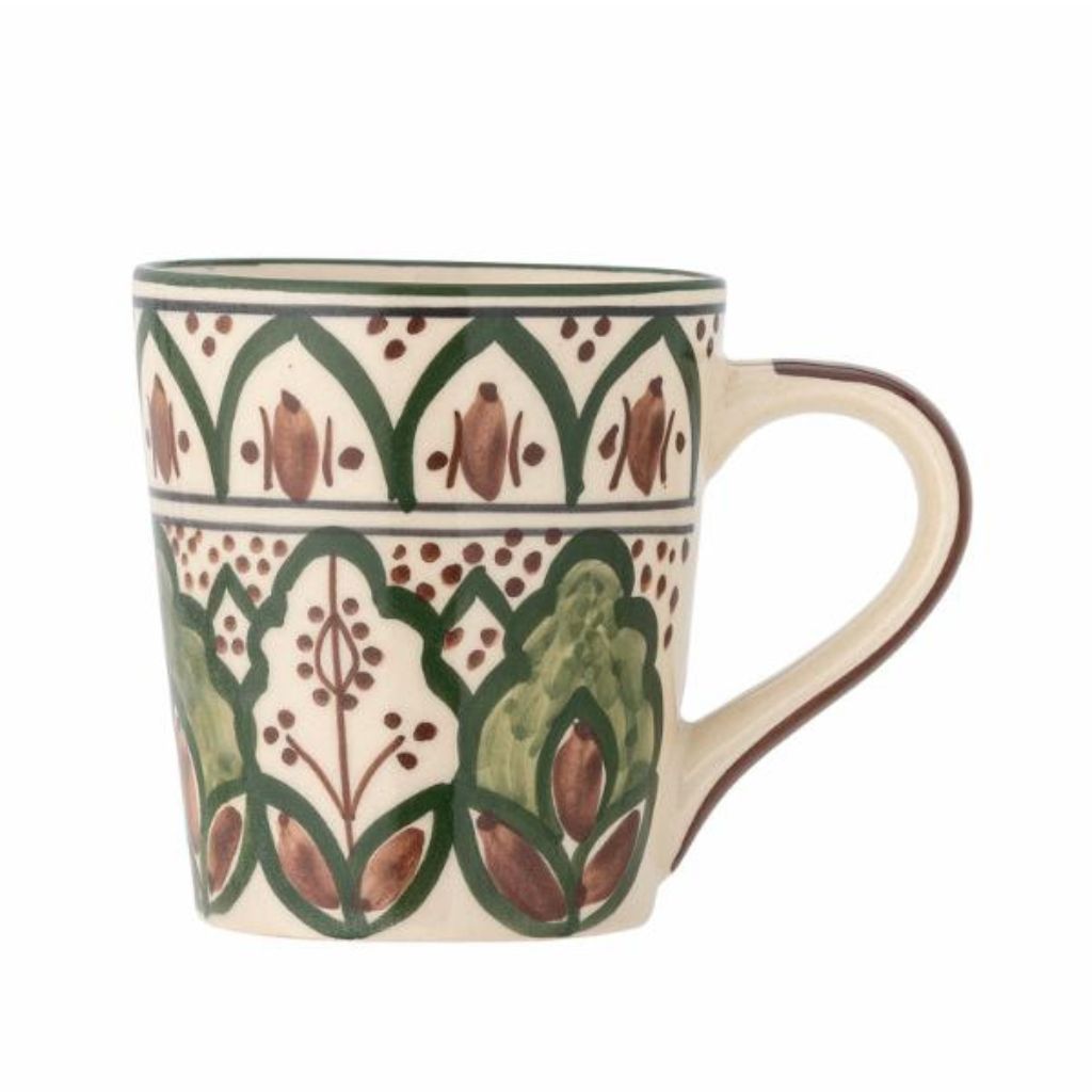 Decorative mug with green and brown pattern on a white background