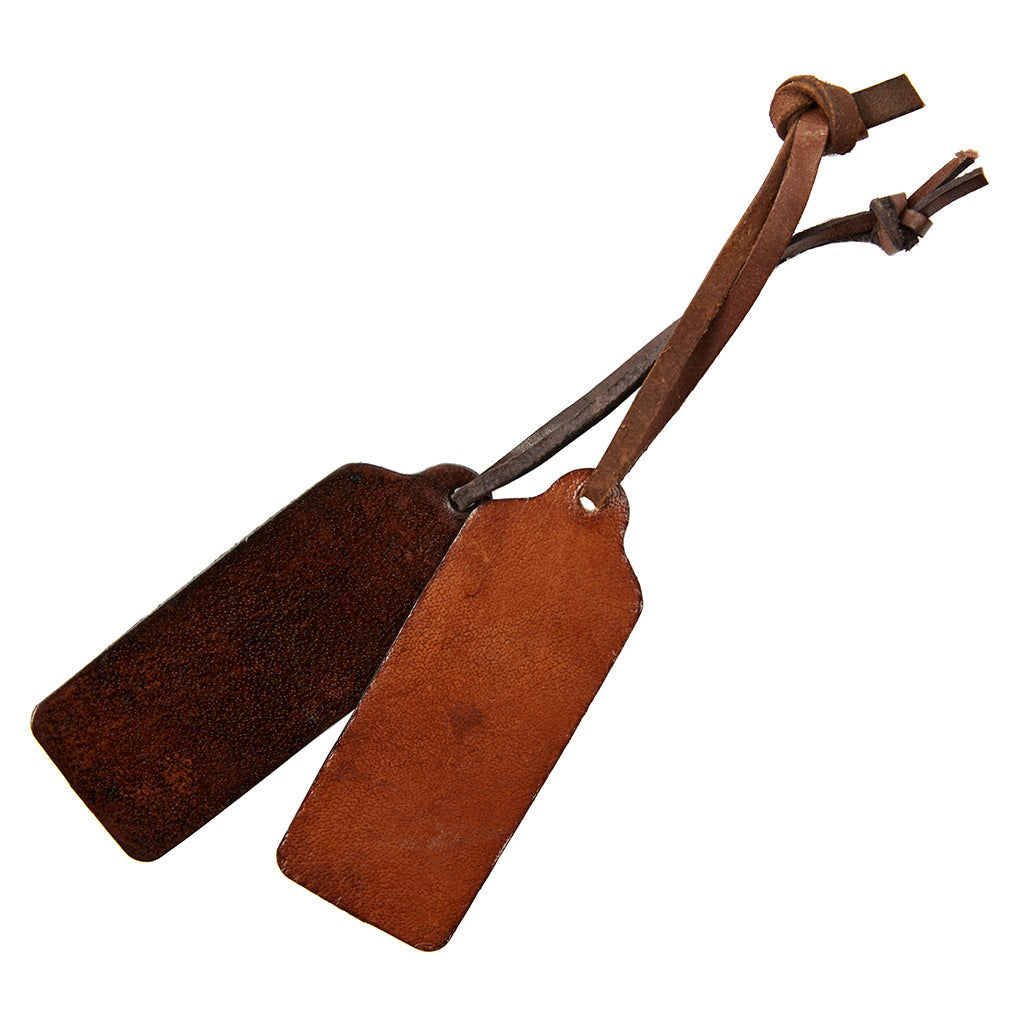 Two brown leather luggage tags with a strap, one with a visible personalized engraving