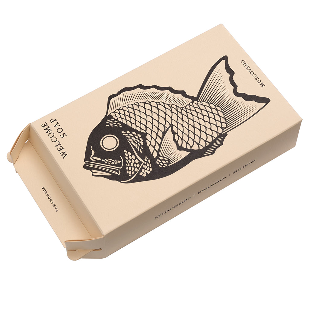Beige soap box with black fish illustration on a white background