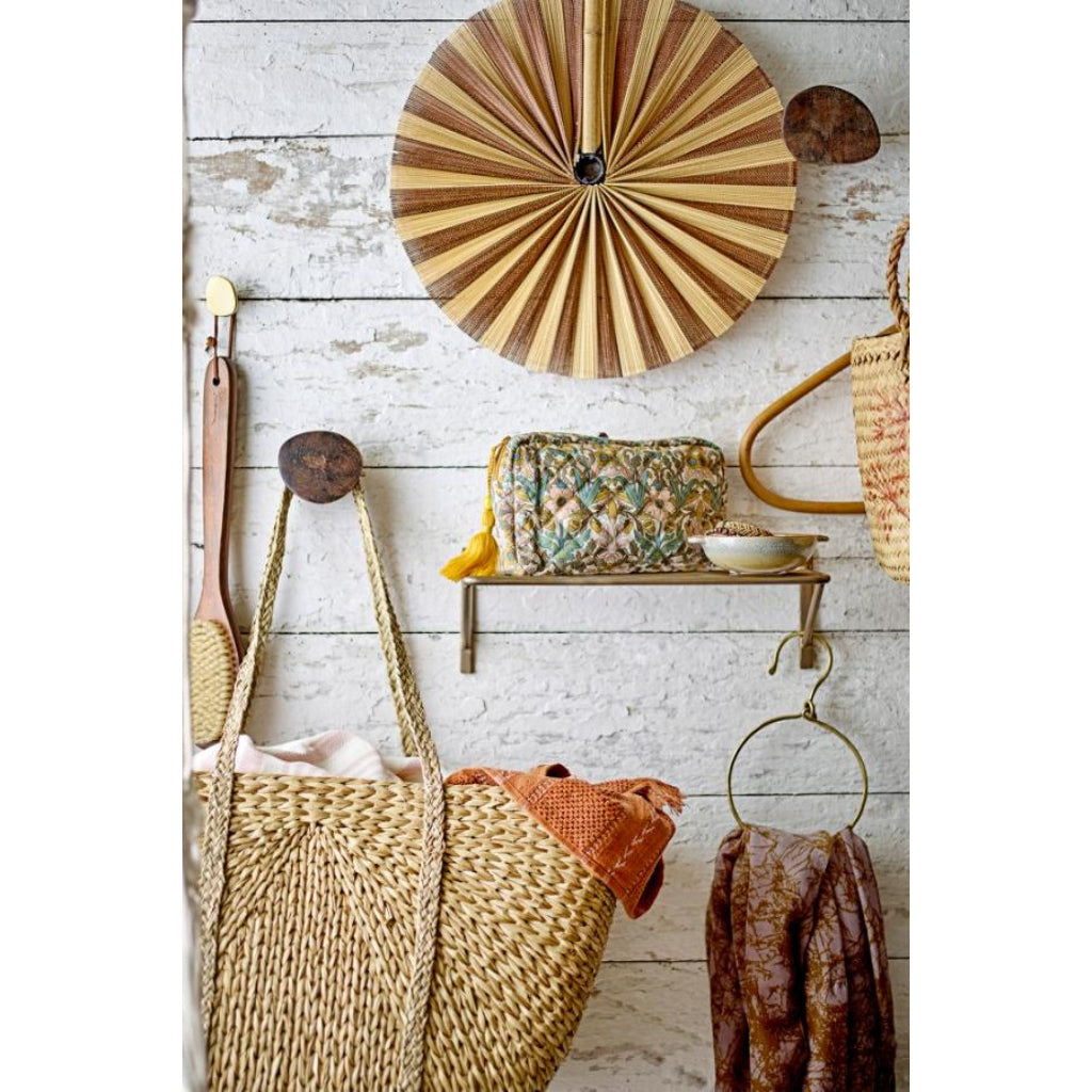 Decorative wall with wicker basket, round wooden wall art, and various items on a rustic wooden surface.