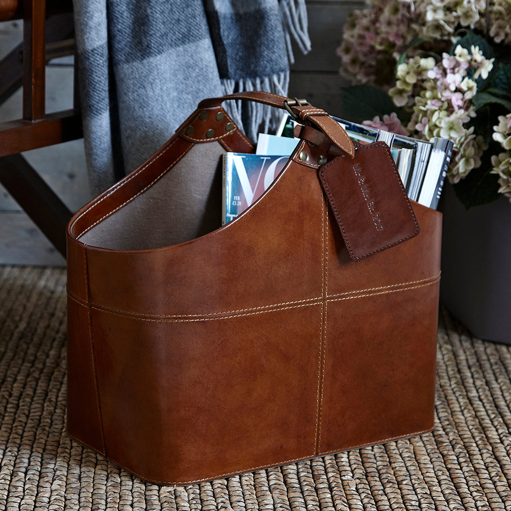 Leather buckled magazine basket, with a personalised luggage tage
