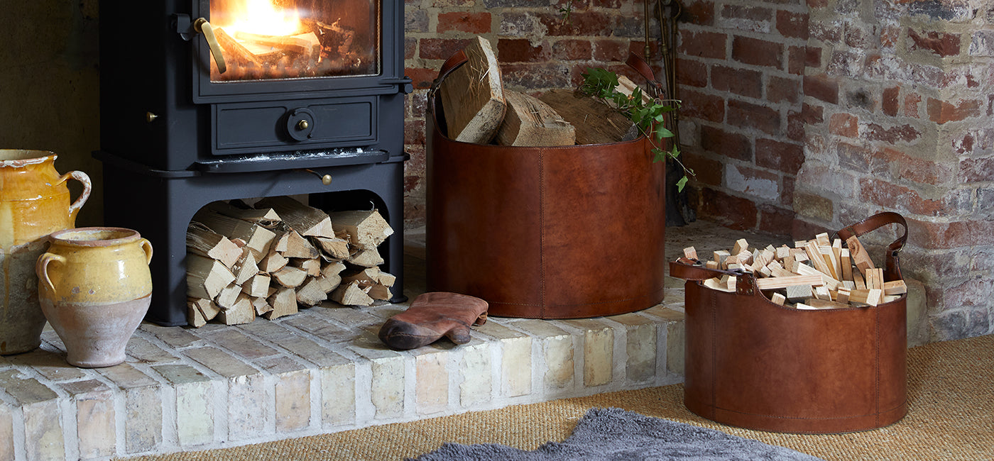 Leather round log basket and matching smaller basket in the hearth with wood burner  and leather glove for fires and oven