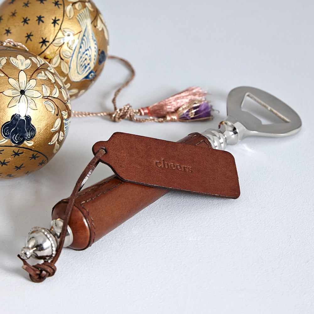Conker brown leather mini tag attacehd to the handle of a leather bottle opener