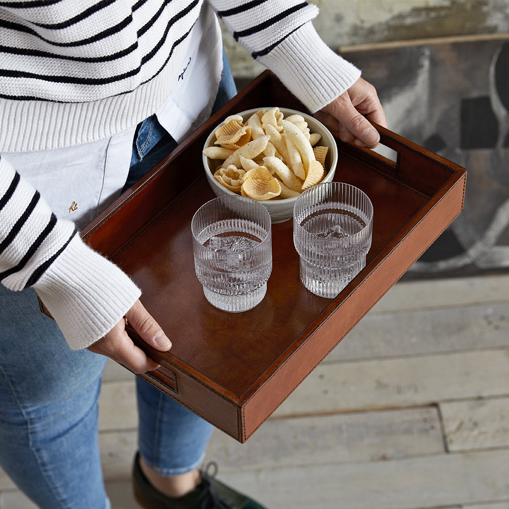 Conker leather cofee tray being carried by person with drinks and bowl of crisps