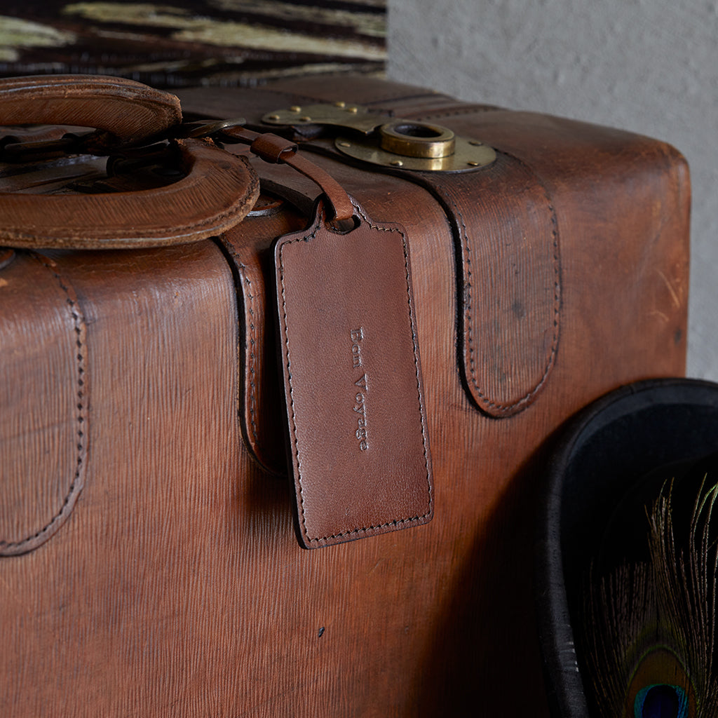 Conker brown personlised leather luggage tag on suitcase