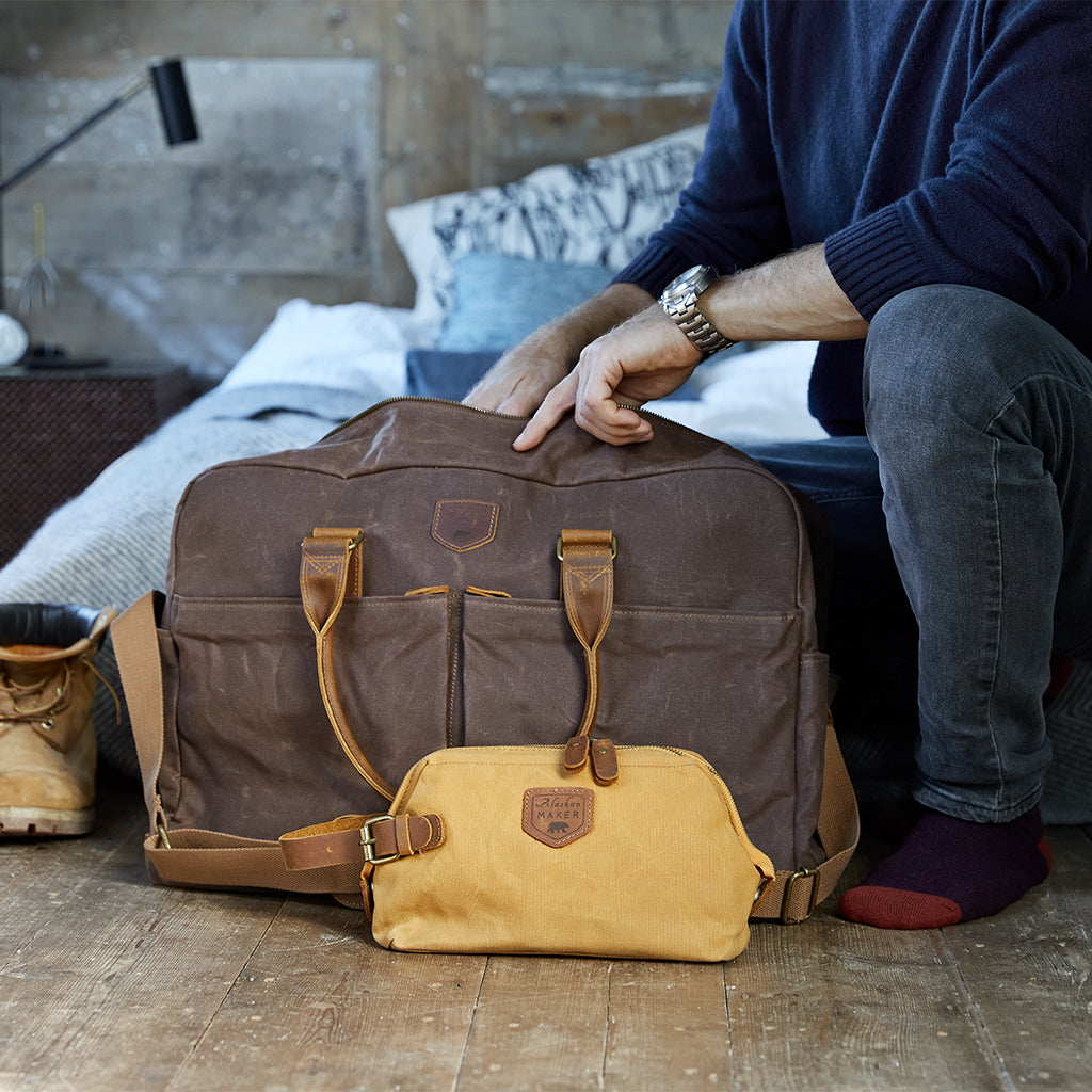 Brown waxed canvas weekend bag with mustard toiletry bag