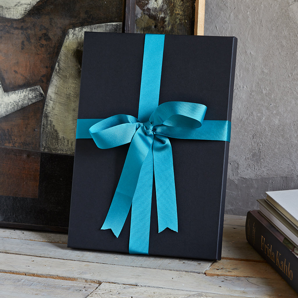 Gift box tied with a blue ribbon, ideal presentation for a gift of a travel wrap