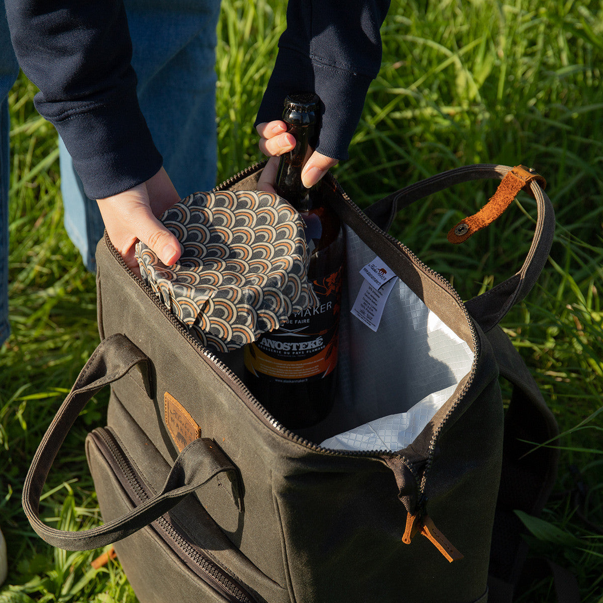 Waxed canvas picnic backpack with the zipped top open to shown the insides