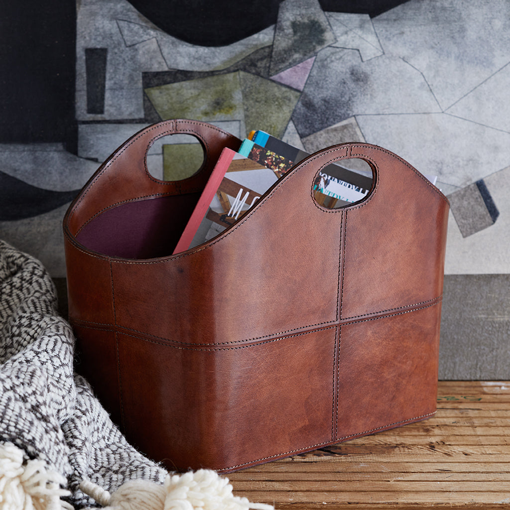 Leather storage basket with integrated handles and curved lines
